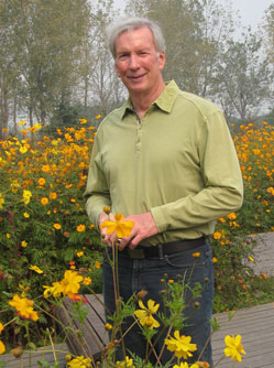 A man standing in front of some flowers